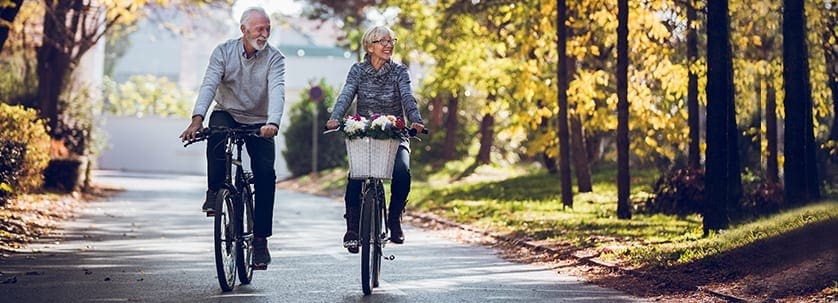 A couple enjoys one of their healthy aging habits: biking outdoors (Longbridge Financial - Reverse Mortgage)