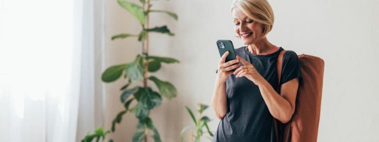 middle aged woman after yoga class looking at her phone