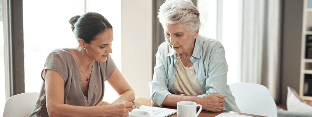 young-woman-assisting-her-elderly-mother-with-her-finances-at-home