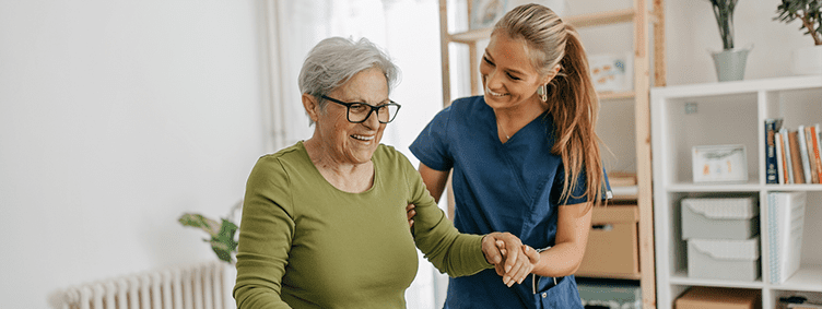 female-caregiver-helping-and-supporting-senior-patient-to-walk-at-home