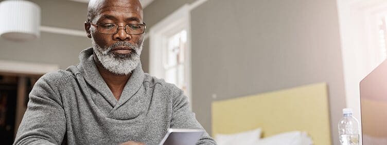 shot-of-a-senior-man-using-a-mobile-device-while-working-on-his-finances-at-home