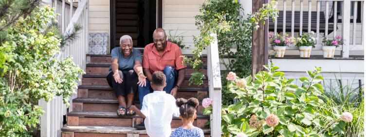 senior grandparents on porch at home with grandchildren