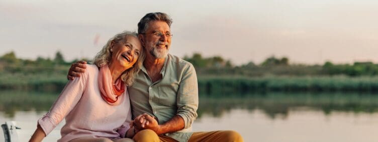 happy mature couple on boat during dusk in the summer